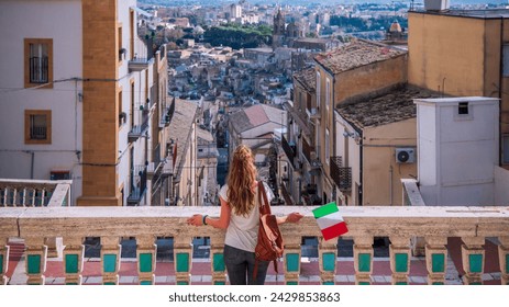 woman on blacony looking at panoramic view of caltagirone, Sicily island in Italy