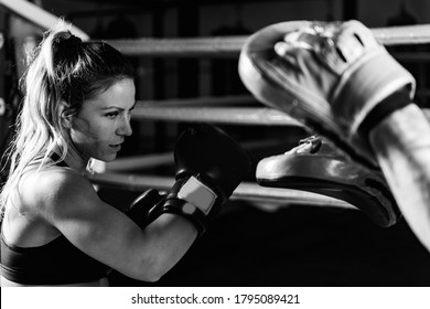 Woman on boxing training with personal trainer. Black and white