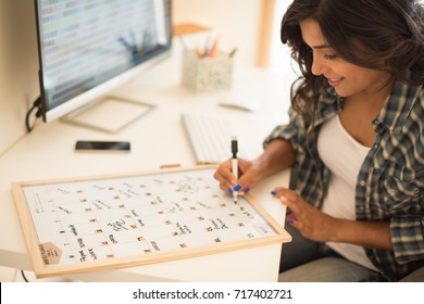 Woman On Computer Desk Writing On A Calendar