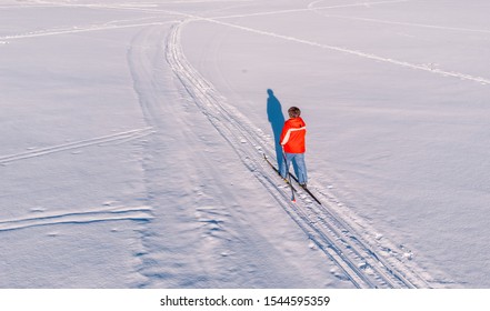 Woman On Cross-country Skiing Rides On Snowy Track. Leisure Concept. Aerial Top View.