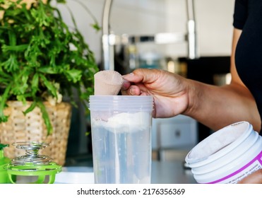 A Woman On Diet Preparing Breakfast Drink Making Liquid Meal From Plant Base Protein Powder With Chocolate Powder At Home, Closeup