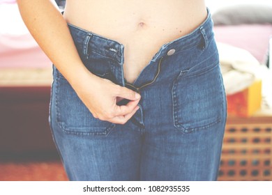 Woman On Diet Unzipping Her Pants Zipper
