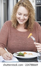 Woman On Diet Writing Details In Food Journal