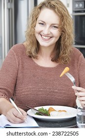 Woman On Diet Writing Details In Food Journal