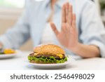 Woman on dieting for good health concept. Woman doing cross arms sign to refuse junk food or fast food hamburger that have many fat.