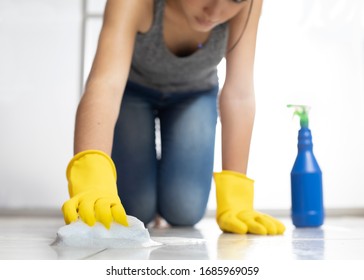 Woman On Her Knees Disinfecting Ceramic Floor With Gloves, Sponge, Spray, Water And Soap,gloves,knees,soap,foam,shiny,bright,latex,coronavirus,covid-19,pandeia,contagion