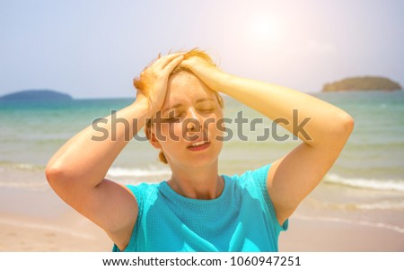 Woman on hot beach with sunstroke. Health problem on holiday. Medicine on vacation. Dangerous sun. Beach life. Sunstroke on sunny beach. Girl on beach. Health threat on vacation. Holiday health care