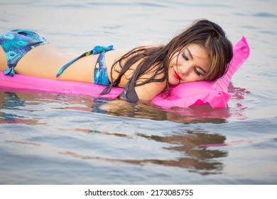 Woman On Inflatable Swimming Pool Bed Enjoying Sun Tanning.
Summer Vacation Bikini Girl. Woman Relaxing On Pink Air Mattress Bed Floating On Raft In The Sea.