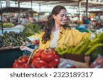 Woman on the market. Mature Female Customer Shopping At Farmers Market Stall. Woman shopping at the local Farmers market. Beautiful woman buying vegetables.