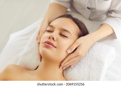 Woman on massage bed or examination table getting cosmetic facial treatment for evening out skin tone, rejuvenating, lifting skin and brightening complexion for clear smooth fresh perfect glowing skin