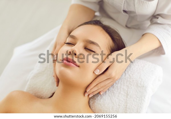 Woman on massage bed or examination table getting
cosmetic facial treatment for evening out skin tone, rejuvenating,
lifting skin and brightening complexion for clear smooth fresh
perfect glowing skin