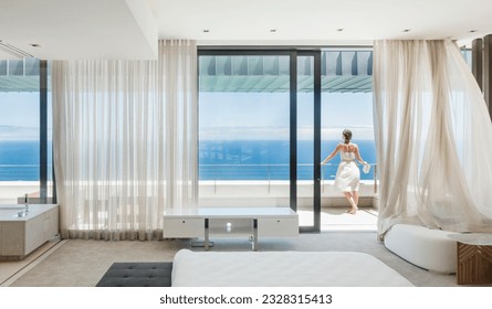 Woman on modern balcony overlooking ocean