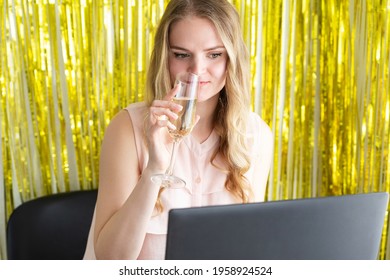 Woman On Online Corporate Party Or Online Dating With A Laptop At The Table Drinks Champagne From A Glass. Internet Event, Virtual Love Concept.