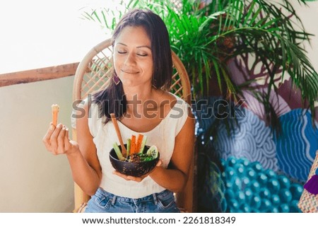 Woman on an organic vegan restaurant, eating a hummus.
