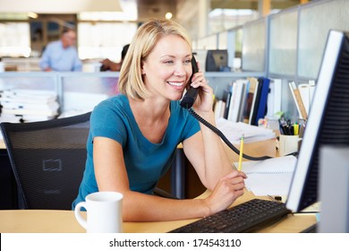 Woman On Phone In Busy Modern Office