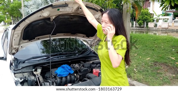 The woman was on the phone, followed a mechanic to\
fix the car.