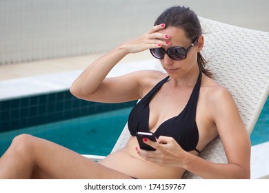 Woman on the phone stressed at the pool 
