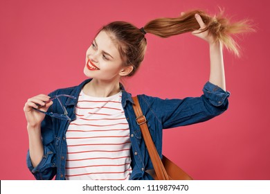 woman on a pink background touching her hair                     