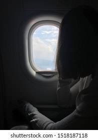 The Woman On The Plane Is Looking Through The Window