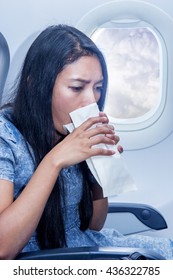 Woman On The Plane Vomited In A Paper Bag. Traveler In A Flying Aircraft Has Nauseous. Nausea Passenger In A Flying Airplane. Turbulence On The Plane.