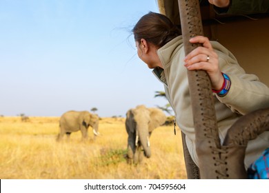 Woman on safari game drive enjoying close encounter with elephants in Kenya Africa