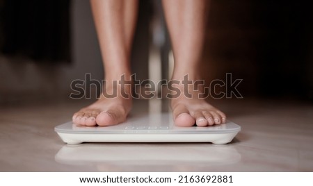 Woman on scales measure weight. Female dieting checking BMI weight loss.