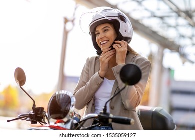 Woman On Scooter Tightens Helmet