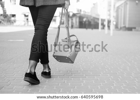 Woman on the street with backpack in hands, black and white