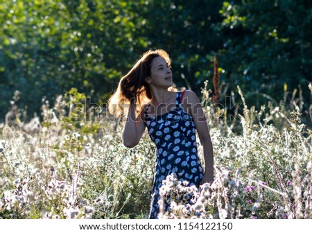 Similar – eine frau vor  einer blumenwiese. blumen pflücken