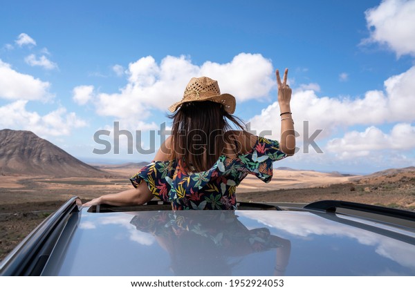 woman on the top of a car looking at the stunning\
landscape of Fuerteventura, Canary Islands, Spain - selective\
focus\
