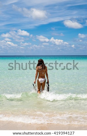 Woman on a tropical beach going for snorkeling