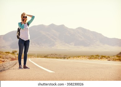 Woman On Vacation Hitchhiking Along Road Using Mobile Phone