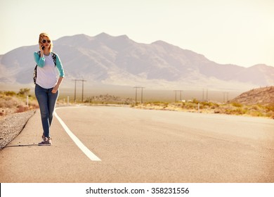 Woman On Vacation Hitchhiking Along Road Using Mobile Phone