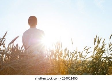 woman on wheat field, rear view