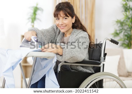woman on a wheelchair ironing