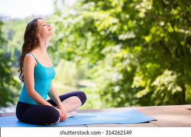 Woman On A Yoga Mat To Relax Outdoor.