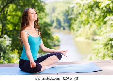 Woman On A Yoga Mat To Relax In The Park.