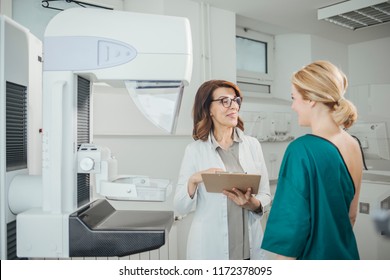 Woman Oncologist Talking With Her Patient On Mammography Examination.