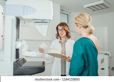 Woman Oncologist Talking With Her Patient On Mammography Examination.