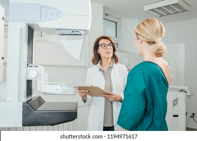 Woman Oncologist Talking With Her Patient On Mammography Examination.