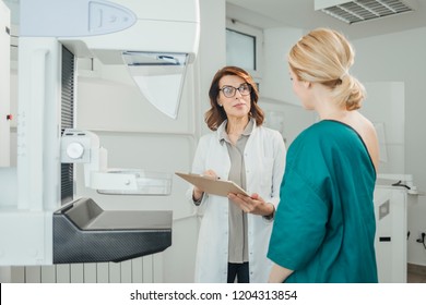 Woman Oncologist Talking With Her Patient On Mammography Examination.