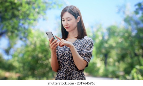 A Woman In A One Piece Is Standing In Front Of The Trees