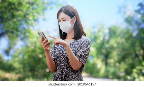 A Woman In A One Piece Is Standing In Front Of The Trees