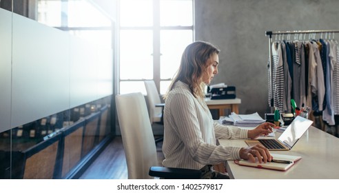 Woman Online Entrepreneur Working On Laptop At Office. Ecommerce Business Owner Working At Her Desk.