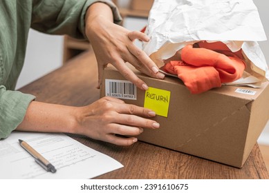 woman online shopper affixes a barcode sticker to a cardboard box, marking it for return and refund. 