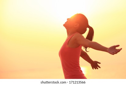 Woman Open Arms Under The Sunrise At Seaside Wellness Concept.