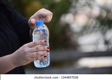 Woman Opening Bottle Of Water In