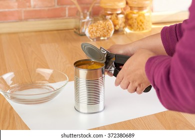 woman opening a can of corn with can opener in the kitchen