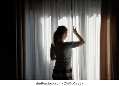 Woman Opening Curtains in Dimly Lit Room - Powered by Shutterstock