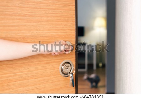 Woman is opening the door to the new flat. Smart home concept